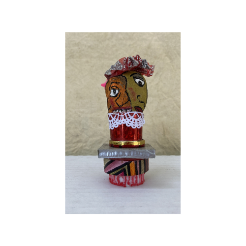 Rocks and an otherwise array of things combined to make the coordinated whole. With a total of 4 faces they are quite dressed up for the day sporting a pretty, glitzy hat, spiky red hair on one side. This is around 4" tall standing on a 2" x 2" tile, aluminum trimmed platform.